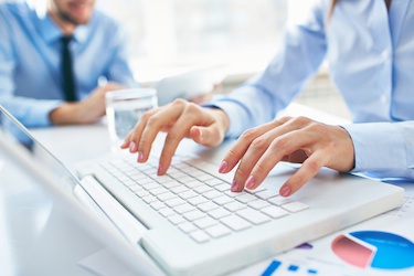 Person typing on a computer (photo)