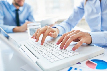 Person typing on a computer (photo)